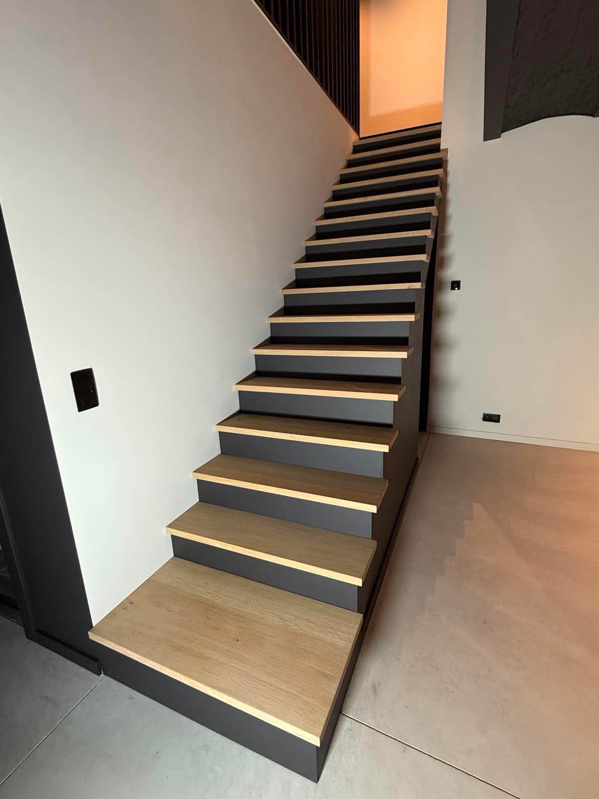 Escalier droit aux marches en chêne clair contrastant avec les contremarches et le limon peints en anthracite.
